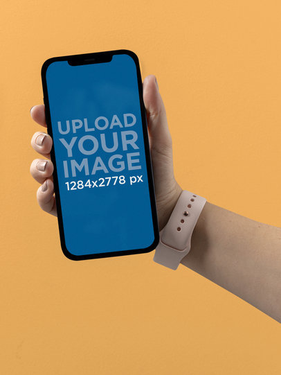 Mockup of the Hand of a Woman Holding an iPhone 12 Pro Max