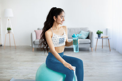 Sports Bra Mockup of a Woman with a Water Bottle Sitting on a Gym Ball