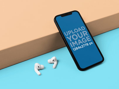 Mockup of an iPhone 12 Pro Max in Portrait Position by a Pair of AirPods m21874