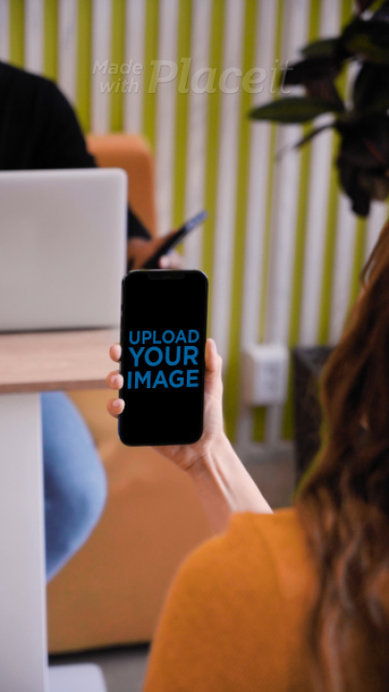 Video of a Woman Holding an iPhone 12 Pro Max at an Office