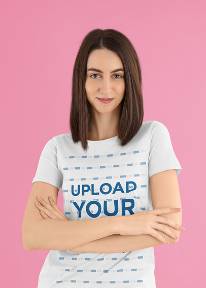 T-Shirt Mockup Featuring a Confident Woman Posing With Her Arms Crossed at a Studio