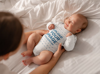 Mockup of a Long Sleeve Heathered Onesie Featuring a Cute Baby Smiling