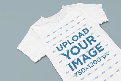 Mockup of a Kids' T-Shirt Lying on a Customizable Surface m13408