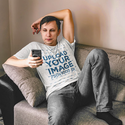 Heathered Tee Mockup of a Serious Man Checking His Phone While Sitting on a Couch m21619-r-el2