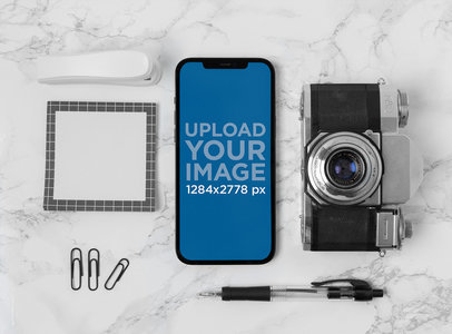 Mockup of an iPhone 12 Pro Max Placed over a Marble Surface by a Retro Camera m21880