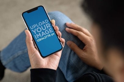 Over-the-Shoulder View Mockup of a Man Checking His iPhone 11 