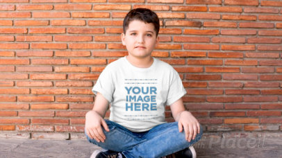 Boy Sitting with his Legs Crossed Wearing a T-Shirt Video Mockup