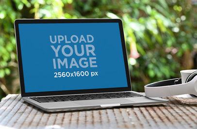 Mockup of a MacBook Placed by Some Headphones