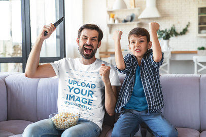 T-Shirt Mockup of a Dad and His Son Cheering at the TV at Home