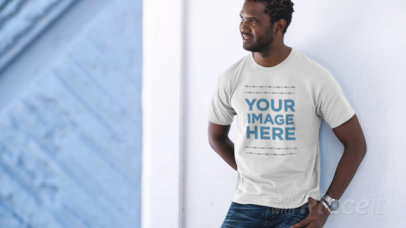 Young Man Laughing Wearing a T-Shirt Video and Leaning Against a Wall