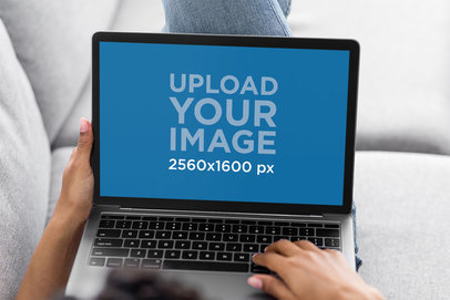Mockup of a Woman Using a MacBook on Her Couch