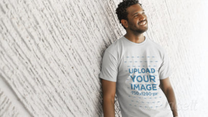 Video of a T-Shirt Being Worn by a Young Handsome Black Man Smiling and Chilling Against a Textured Wall a12777