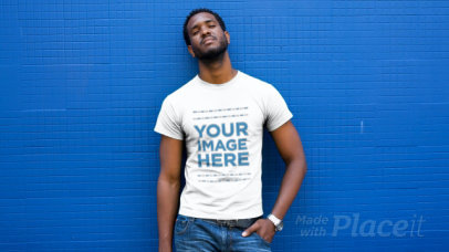 Young Man Wearing a T-Shirt Video Standing Against a Blue Wall