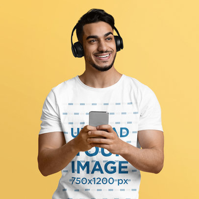 Crewneck T-Shirt Mockup of a Smiling Man with Headphones Using His Smartphone