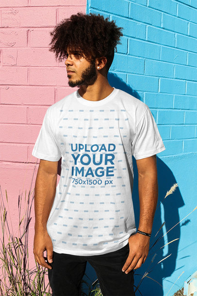 Round-Neck T-Shirt Mockup Featuring a Man Leaning on a Wall