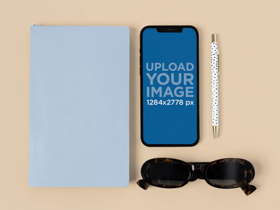 iPhone 12 Pro Max Mockup Featuring a Notebook and a Pair of Fashionable Sunglasses m21870