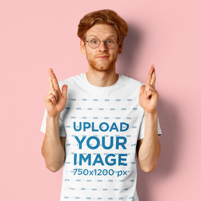 T-Shirt Mockup Featuring a Young Man Crossing His Fingers at a Studio