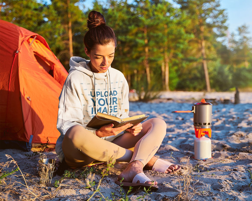 Hoodie Mockup of a Camper Reading While Her Food is Ready