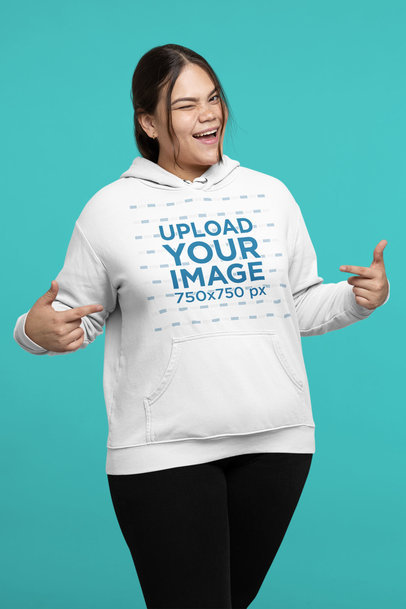 Mockup of a Woman Pointing at Her Hoodie While Winking to the Camera