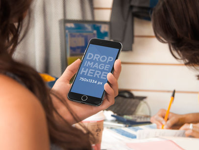 Mockup of a Woman Holding an iPhone 6 while Shopping