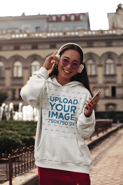 Pullover Hoodie Mockup of a Happy Woman with Headphones and Sunglasses