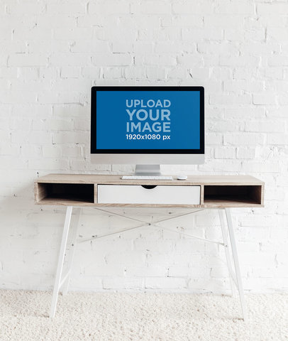 Mockup of an iMac Placed on a Desk Against a White Wall