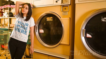 Young Woman Wearing a T-Shirt Cinemagraph Mockup Against a Washing Machine at a Laundry a13402