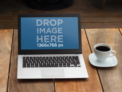 Mockup of a Laptop on a Wooden Table Next to Coffee