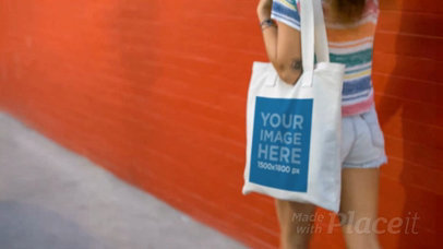 Young Pretty Girl Carrying Tote Bag Video Against a Red Wall a13715