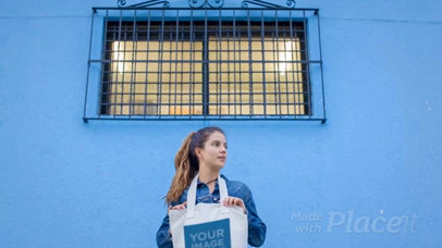 Girl Holding a Tote Bag Video While Standing Near a Blue Bricks Wall a13716