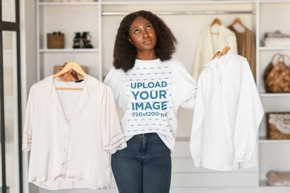 Sweatshirt Mockup of a Woman with a Wondering Expression Holding Two Shirts