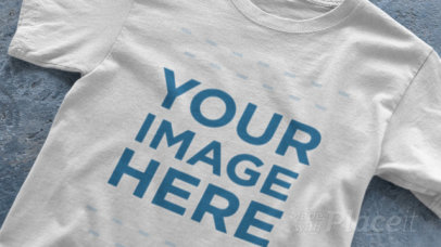 Closeup of a Single T-Shirt Video Mockup Spread Over a Concrete Surface