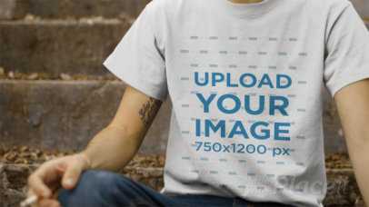 Dude Wearing a T-Shirt Video Sitting on a Concrete Stairway