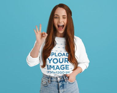 Sweatshirt Mockup of a Long-Haired Woman Making an Ok Sign While Winking