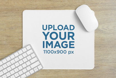 Mockup of a Customizable Mousepad Featuring a Wooden Desk and a Computer Keyboard