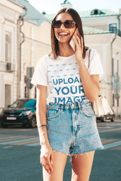 Tee Mockup of a Happy Woman with Sunglasses Talking on Her Smartphone