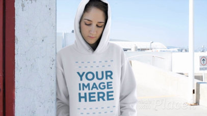 Woman Wearing a Hoodie Video Mockup Leaning Against a Wall