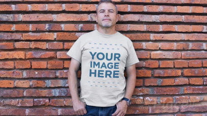 Middle-Aged Man Standing Against a Bricks Wall Wearing a Round Neck T-Shirt Video Mockup