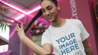 Pretty Young Woman Wearing a Round Neck Tee Video Mockup Indoors