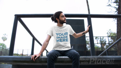 Video of a Guy with Long Hair and a Beard Sitting on a Ledge Wearing a Round Neck Tee Mockup a12977