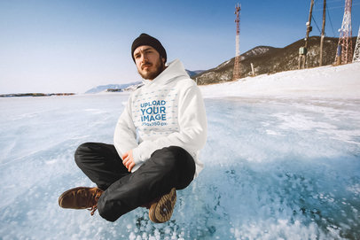 Hoodie Mockup of a Man Sitting on a Frozen Lake