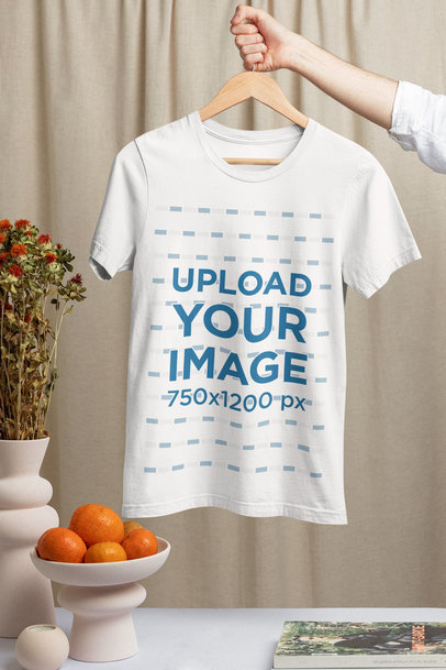 Mockup of a Man Holding a Hanger with a Bella Canvas T-Shirt Featuring Ceramic Pottery