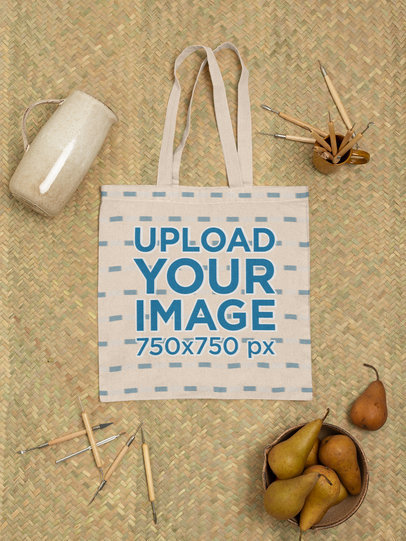Mockup of a Tote Bag Laid Flat on a Jute Surface Next to a Piece of Pottery m23505