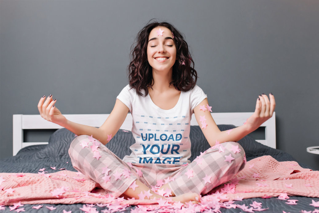 T-Shirt Mockup Featuring a Joyful Woman Meditating on a Bed