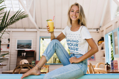 T-Shirt Mockup Featuring a Happy Woman Holding a Beverage