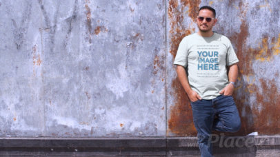 Video of a Man Wearing a Plus Size T-Shirt in a Sunny Day Against a Rusty Wall a12465