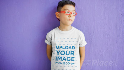 Boy with Glasses Standing in Front of a Purple Wall Wearing a Kid's Tee Video