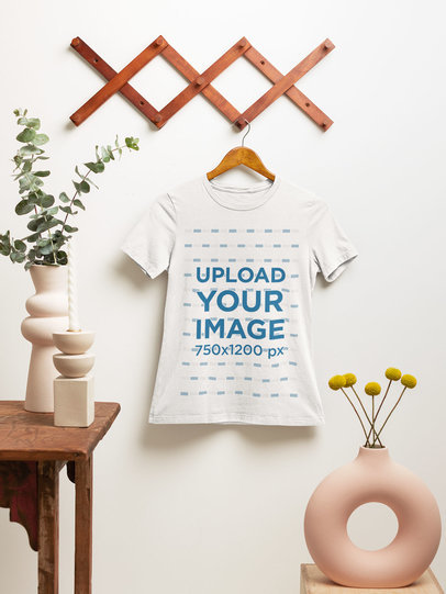 Mockup of a Bella Canvas T-Shirt on a Wooden Hanger Featuring a Minimalistic Set