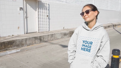 Woman Wearing a Hoodie Video and Sunglasses Sitting on Bumper Industrial Street a13095