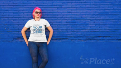 Woman with Pink Hair Wearing a Round Neck Plus Size Tee and Leaning Against a Bright Blue Wall